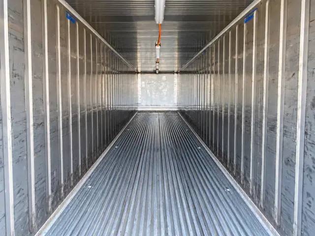 Interior de un container refrigerado: paredes de aluminio corrugado, piso ranurado y conductos de aire en el techo